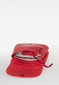 Borsa di pelle rossa con chiusura a patta e bottone a pressione. L'interno presenta una tasca con zip e una fodera di tessuto con slot per carte. Texture morbida.
