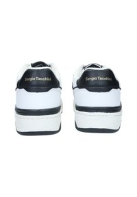 Sneakers bianchi con tomaia in pelle liscia, dettagli neri sul tallone e logo del marchio dorato. Presentano una suola bianca spessa per un'altezza aggiuntiva.