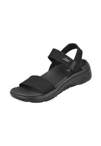 Sandal negra con correas de malla, plantilla acolchada, suela texturizada y soporte para el arco. Diseñada para la comodidad y la estabilidad.