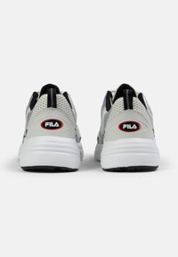 Scarpe da ginnastica bianche e grigie con pannelli in rete, colli imbottiti e un anello di trazione. Presentano il logo FILA rosso e nero sul tallone.