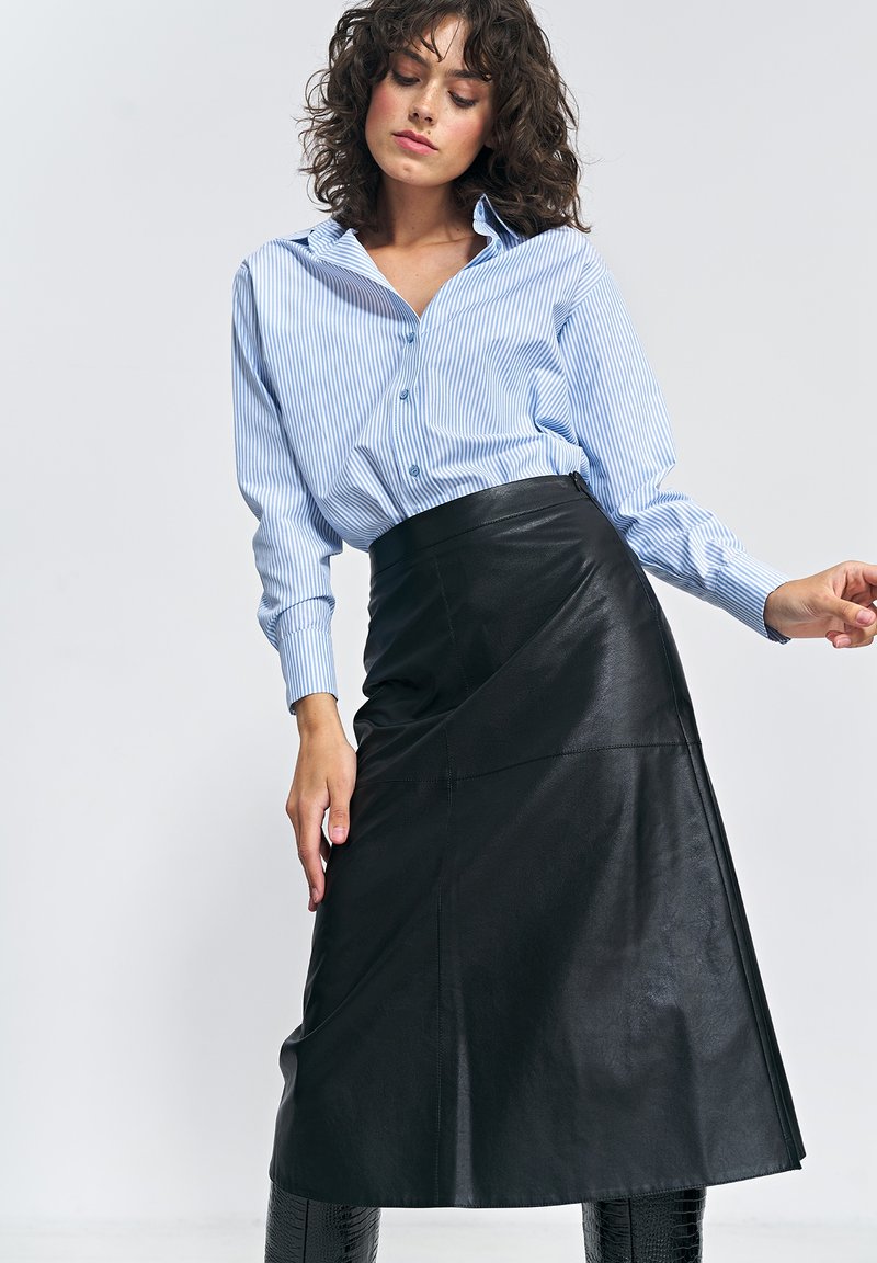 Czarna skórzana spódnica o kopertowym kroju, zestawiona z koszulą na guziki w jasnoniebiesko-białe paski. Gładka faktura, długość do kolan, eleganckie dopasowanie.