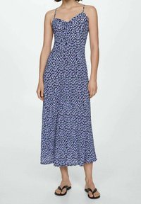 Robe longue à motifs floraux violets et noirs, avec bretelles spaghetti réglables et tissu léger et fluide qui tombe jusqu'aux chevilles.