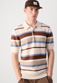 Kortermet strikket poloskjorte i beige med horisontale striper i brun, lysebrun og lyseblå. Har klassisk krave og knapper.