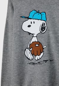 Sudadera gris con un dibujo animado de Snoopy con una gorra azul, sosteniendo un guante de béisbol marrón, con detalles en contorno negro.