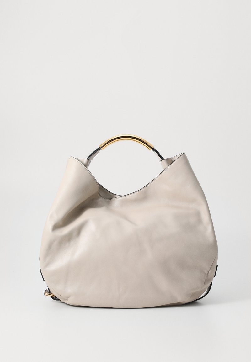 Light grey leather handbag with a smooth texture, oversized shape, and a gold-tone curved handle. Simple design with minimal accents.