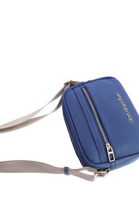 Bolso cruzado azul con una superficie suave y mate. Presenta un bolsillo frontal con cremallera y una correa ajustable beige. Forma rectangular compacta.