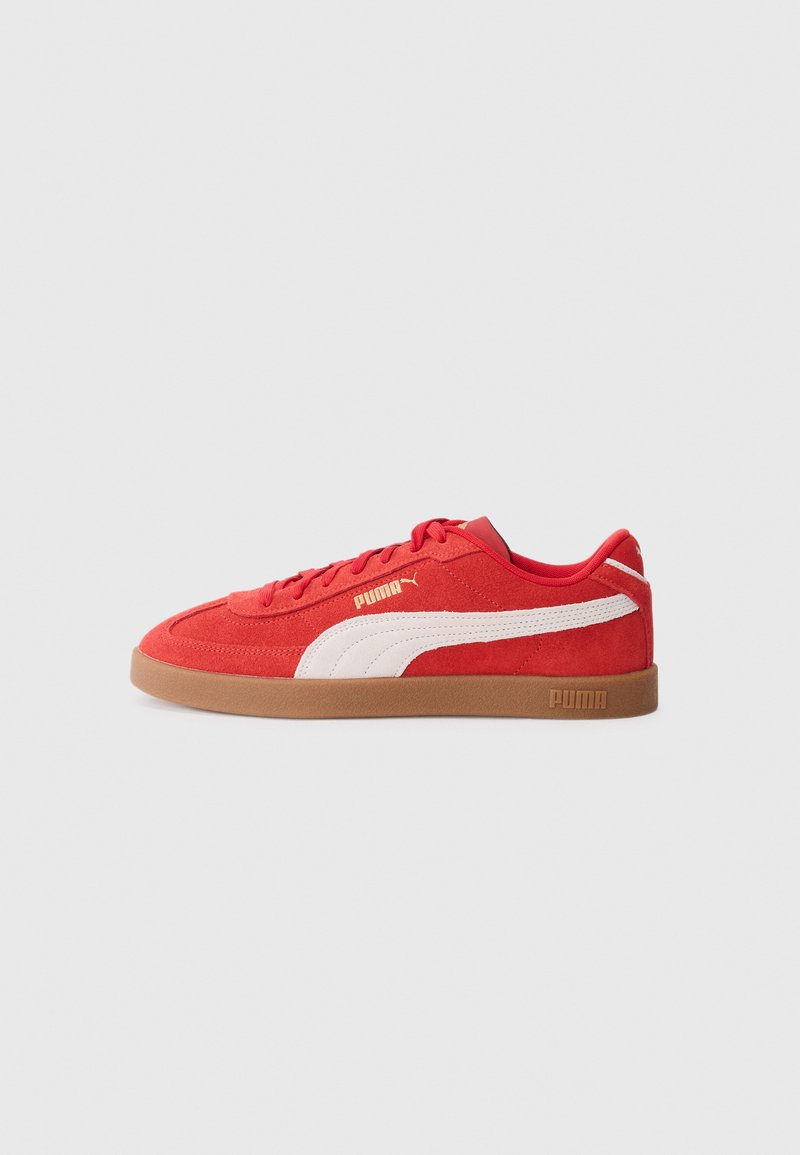 Røde ruskinds sneakers med hvid lateral stribe og logo, flad gummisål, rund tå og seks øjetter til snørebånd.