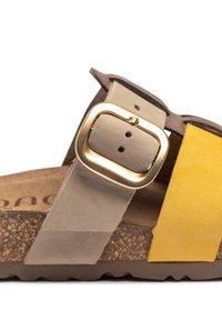 Cork-soled sandal features beige and yellow suede straps with a gold metal buckle. The design includes a textured footbed and rubber outsole.