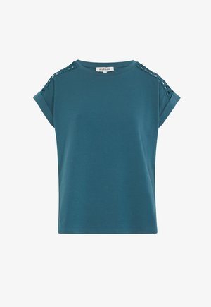 Tummansiniharmaa puuvillapaita, jossa on lyhyet kääntöhiat, olkapäillä nyöritys yksityiskohtana ja rento leikkaus. Sujuva pinta; rento muotoilu.