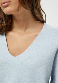 Maglione a maglia blu chiaro con scollo a V, finitura testurizzata e dettagli sottili lungo il colletto e le maniche.