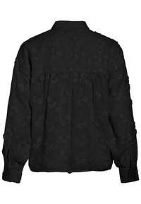 Svart långärmad skjorta med texturerat blommönster, knäppning vid handlederna och en avslappnad passform. Har en bakre yoke och mjukt tyg.