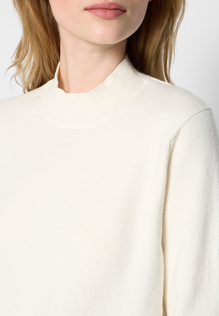 Weißer hochgeschnittener Pullover aus weichem, strukturiertem Stoff, mit einem lässigen Schnitt und dezenten Stickdetails am Kragen.