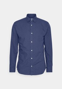 Camicia blu navy con maniche lunghe, caratterizzata da un motivo a pois bianchi, colletto classico e una finitura in tessuto testurizzato.