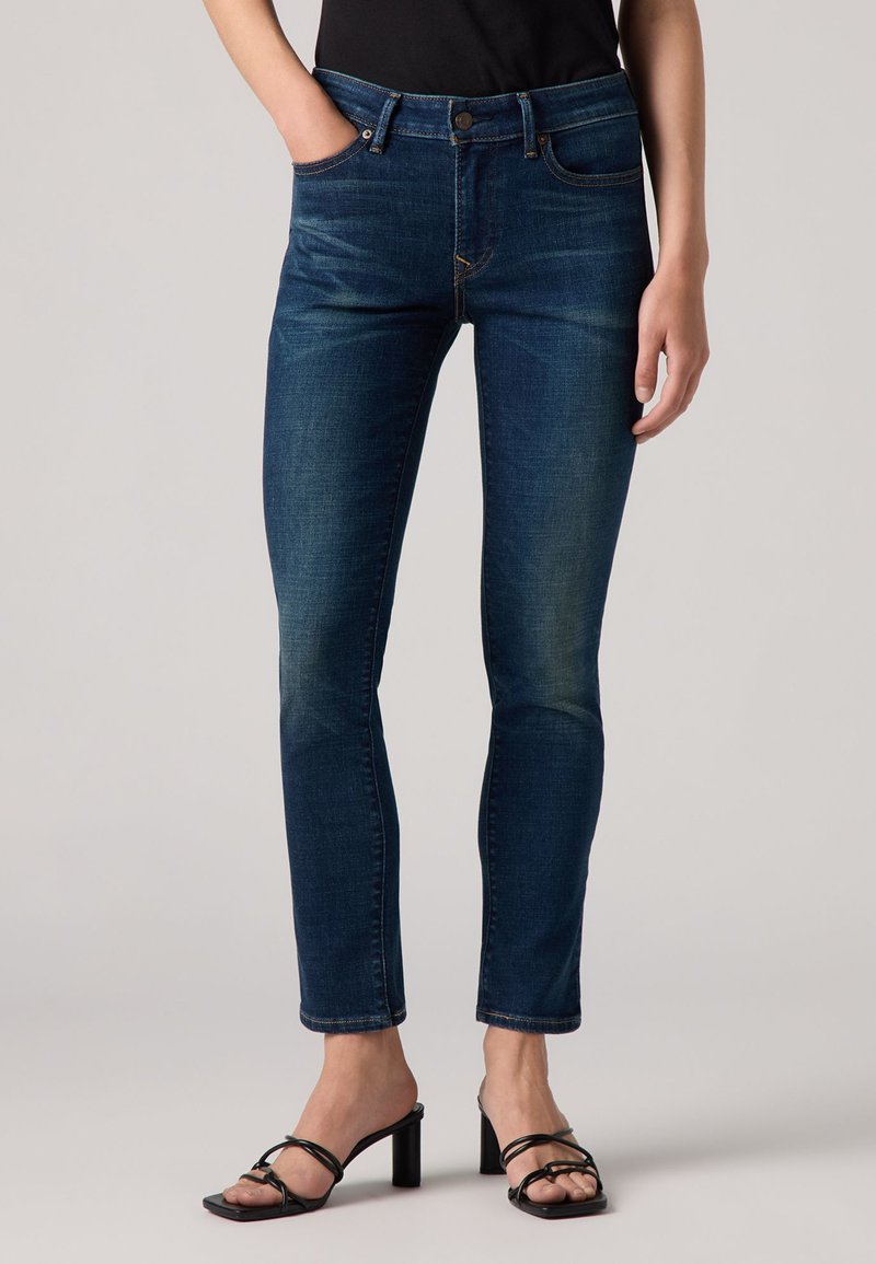 Dunkelblaue Denim-Jeans im Slim-Fit, mit Fünf-Taschen-Design, Kontrastnähten und leichtem Verblassen an den Oberschenkeln.