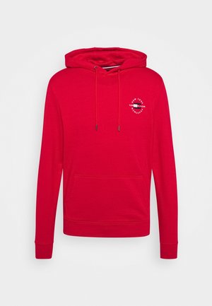 Sweat à capuche rouge avec poche avant, cordons ajustables et petit logo blanc circulaire sur la poitrine gauche.