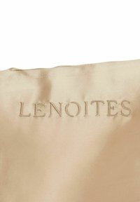 Beige satinfiber med broderad text "LENOITES" i en subtil ton-i-ton-tråd, som visar en slät textur och en stilren design.