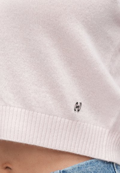 Világos rózsaszín kötött pulóver bord�ázott szegéllyel és egy apró, fémes logóval az aljánál. Sima textúrájú, casual kialakítású.