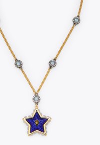 Złoty naszyjnik z łańcuchem i zawieszką w kształcie gwiazdy, ozdobiony fioletowymi kamieniami, centralnym złotym emblematem oraz okrągłymi akcentami z opalu po bokach.