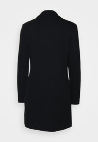 Cappotto nero con revers, maniche lunghe e taglio dritto. Texture liscia, dettagli minimi e design di lunghezza media.
