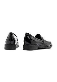 Black leather loafers with a glossy finish, low rubber soles, and minimal stitching details. Design is sleek with no visible patterns.