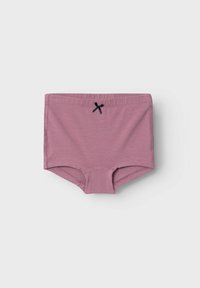 Lilla bomullsshorts har en jevn tekstur, høy midje, og en liten svart sløyfe som accent i midten foran.