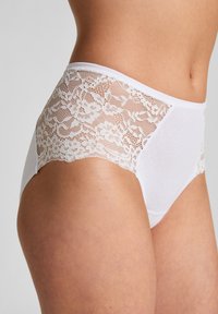Weiße, vollständig bedeckende Slips mit floralen Spitze-Seitenpaneelen, weichem Baumwollmaterial und einem glatten Bund für zusätzlichen Komfort.