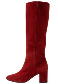 Czerwone zamszowe botki za kolano z kwadratowym noskiem i masywnym obcasem. Posiadają gładką teksturę oraz dopasowany fason cholewki.