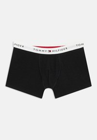 Μαύρα ανδρικά μποξεράκια με λευκή ελαστική ζώνη μέσης που φέρει το λογότυπο και τη σημαία Tommy Hilfiger στο κέντρο.