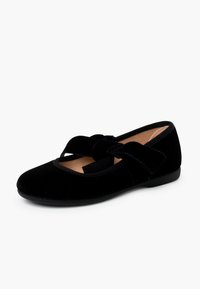 Bailarinas de terciopelo negro con punta redonda, amplia cinta de tela con un acento de lazo y suela plana de goma. Textura suave en todo.