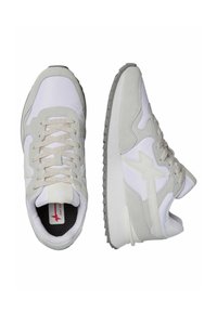 Sneakers grigio chiaro e bianchi con una parte superiore testurizzata, pannelli lisci e una suola imbottita. Presentano lacci e un dettaglio di logo discreto.