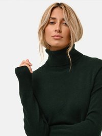 Donkergroen coltrui van een zachte, gestructureerde stof. Beschikt over lange mouwen met ribgebreide manchetten, die zorgen voor een snug fit rond de hals.