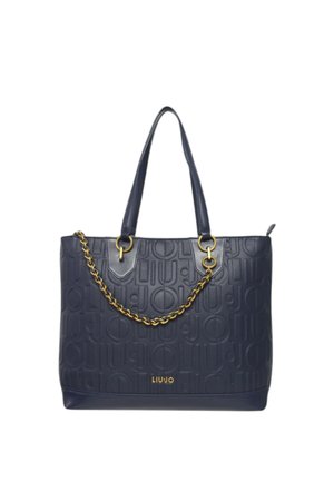 Bolso tote de cuero azul marino con patrón de logo en relieve, doble asa superior y un detalle de cadena en tono dorado. Presenta un amplio compartimento principal.