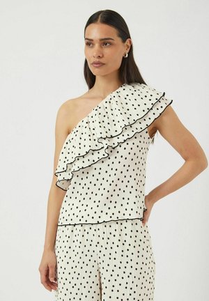 White top with black polka dots, featuring a ruffled one-shoulder design and contrasting black trim. Smooth texture with pleated detail.