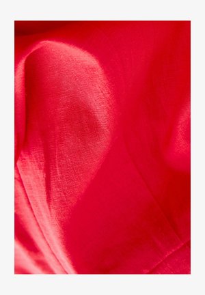 Tessuto rosso brillante con una superficie liscia, che mostra lievi pieghe e drappeggi morbidi. Il materiale appare leggero e traspirante.