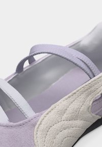 Μωβ και λευκό παπούτσι στυλ Mary Jane με υφασμένο λευκό πέλμα και δύο ελαστικές λουρίδες στο πάνω μέρος.