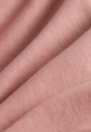 Minkšta rožinė medžiaga, kurioje matyti lygi, nežymiai tekstūruota paviršius su smulkia, tankia pynimu. Pastebimos subtilios atspalvių variacijos.