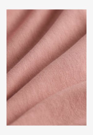 Blødt lyserødt stof, der viser en glat, let tekstureret overflade med fine, tætte vævninger. Subtile variationer i farvetone er synlige.