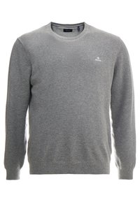 Maglione grigio lavorato a maglia con colletto rotondo, polsini e vita a coste. Presenta un piccolo logo sul lato sinistro del petto e un tessuto strutturato.