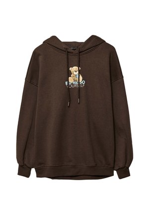 Brun huvtröja med en björnsgrafik och texten "UTTRYCK DIG SJÄLV" i ljusblått. Tillverkad av mjukt material med avslappnad passform och dragsko.