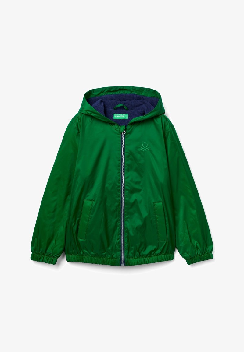 Chaqueta verde ligera con capucha, cierre de cremallera, dos bolsillos laterales y puños elásticos. Presenta un forro azul marino y un detalle de logo bordado.