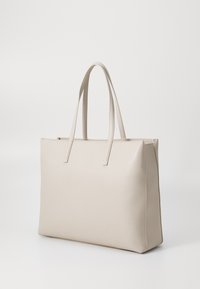 Beige leather tote bag with two straight handles, a rectangular shape, smooth texture, and minimalistic design. Features no visible hardware or patterns.