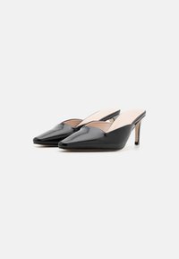 Mules en cuir verni noir avec des bouts pointus, des talons ouverts et des talons de 7,5 cm ; texture lisse ; design minimal.