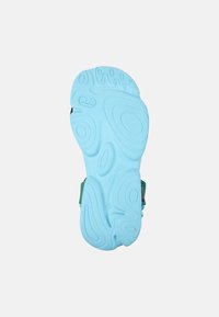 Blue rubber sole with a textured pattern, featuring curves and grooves, complemented by green accents on the sides for added grip.