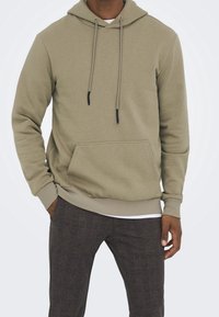 Khaki polarowa bluza z kapturem, wykonana z miękkiego materiału, z przednią kieszenią, ściągaczami w ciemniejszym kolorze oraz ściągaczami na dole i rękawach.
