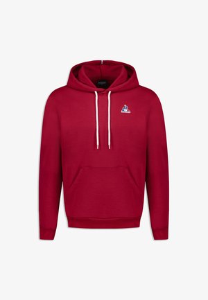 Sudadera roja hecha de tela suave, con un bolsillo frontal, capucha con cordón y un pequeño logo azul en la parte superior izquierda.