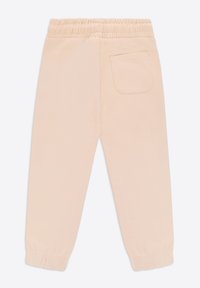 Pantaloni jogger beige chiaro con vita elasticizzata, polsini a costine e una singola tasca posteriore con dettaglio di cuciture semplici.