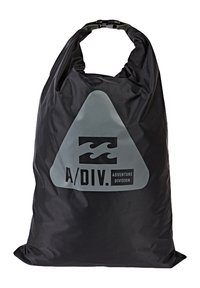 Bolsa negra impermeable con parte superior doblada, que presenta un gran logo triangular gris y el texto "A/DIV. ADVENTURE DIVISION." Textura suave.