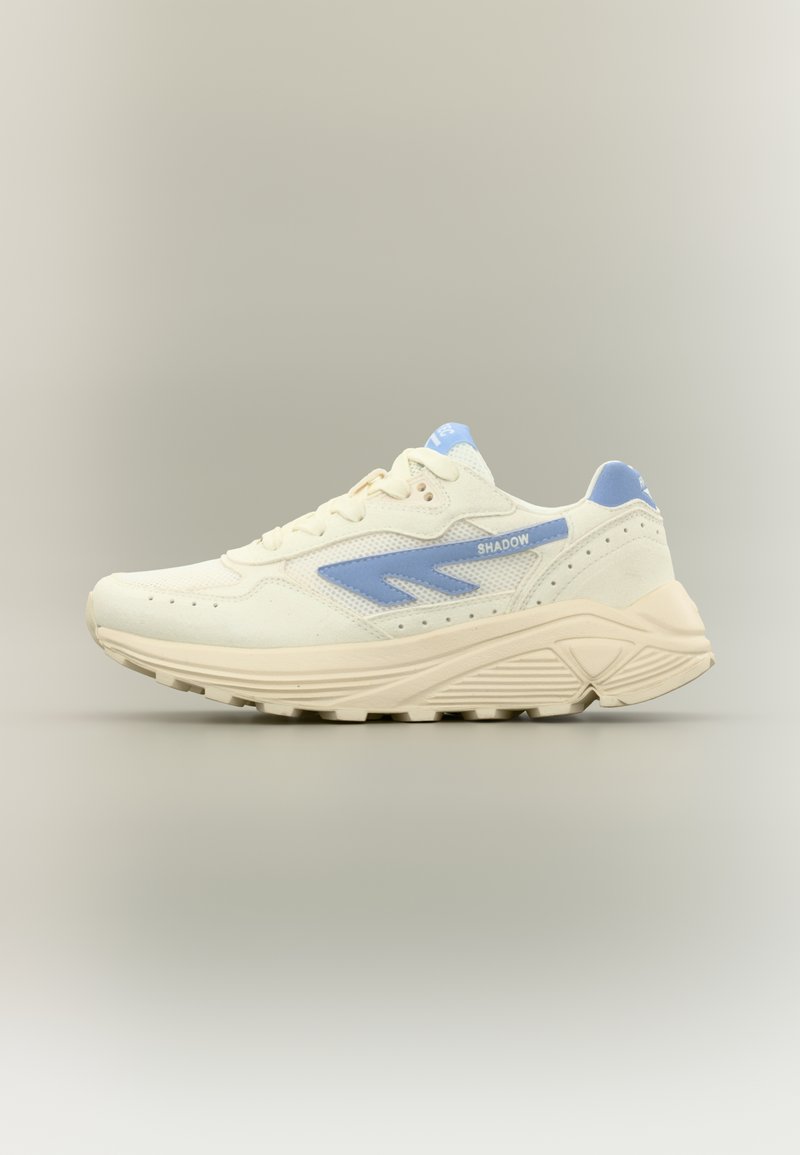 Skriešanas apavi krēmkrāsā un gaiši zilā krāsā. Tiem ir tīkliņa un zamšādas augšdaļa, polsterēts apkaklīte, izteiksmīgas šņorītes un teksturēts gumijas zolējums.