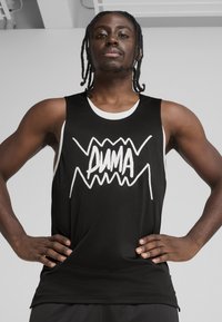 Svart tanktop laget av mesh-stoff, med en fremtredende hvit grafisk logo foran. Utsmykket med hvit halslinning og armhull.