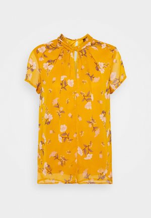 Żółta bluzka z krótkim rękawem w różowo-brązowy kwiatowy wzór, z dekoltem na klucz i małym kołnierzykiem.